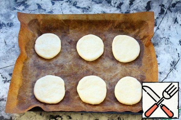 Roll out each ball into a small thick pancake.
Place them on a baking sheet covered with parchment (or floured).
Cover and leave for 30-40 minutes to rise.