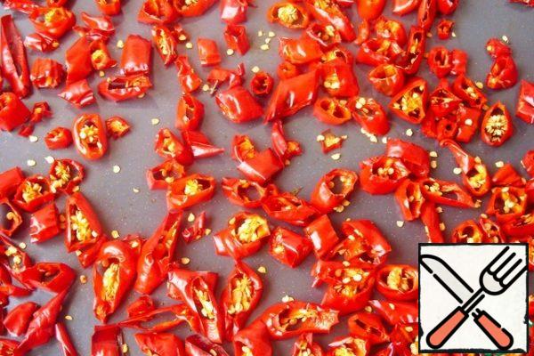Spread the pepper on a baking sheet and send in the oven. Dry it at a temperature of 50-60 degrees until the pepper softens and loses much weight. Do not over-dry it. When squeezing with your fingers, the pepper should no longer secrete juice, but, at the same time, should remain quite soft.