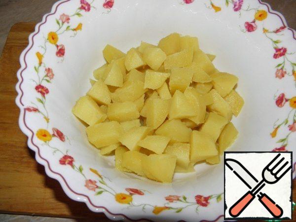Boil potatoes in their skins, cut into medium dice.