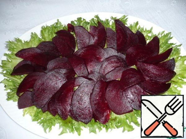 Boil the beets. (This can be done in advance, since the beetroot should be cold in the salad). Peel the beets, cut them into half rings and put them on lettuce leaves.
