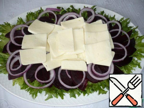 Cut the suluguni cheese into small pieces and put it in the center of the salad.
