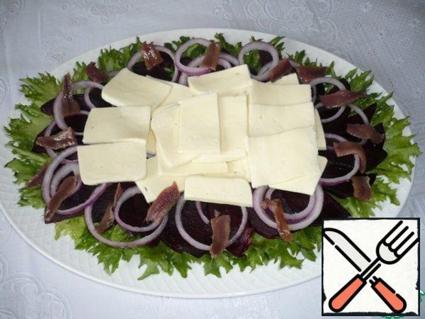 Cut the anchovy fillets into slices and spread them all over the salad.
