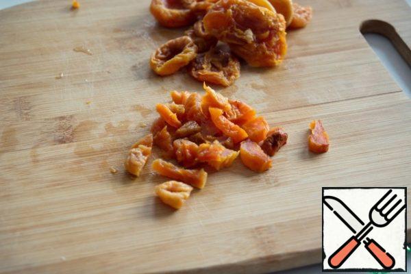 Soak dried apricots in warm water for 15 minutes, dry and cut into small pieces.