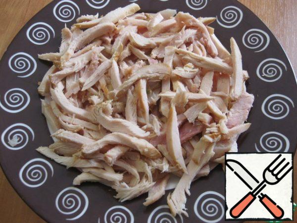 Cut chicken meat into strips, put the first layer on a plate or in a salad bowl, if desired, smear a little with mayonnaise.
