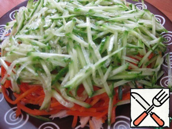 Next, a fresh cucumber, grated on a carrot grater in Korean, or cut into thin strips - this layer is also not lubricated with mayonnaise.
