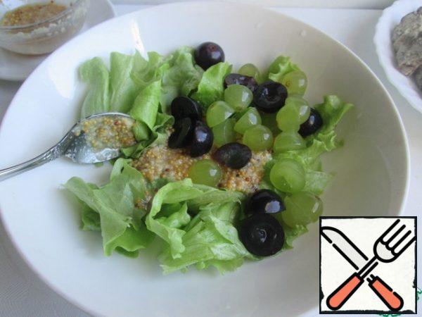 Tear the lettuce leaves with your hands. (You can take any lettuce leaves, or use a mixture of several types).
Cut the grapes in half. If there are bones, then remove them.
Combine the lettuce leaves with the grapes, add the sauce, mix and spread on the liver.
If desired, you can add tomatoes.