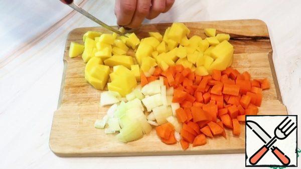 Cut vegetables into cubes: onions, carrots, potatoes.
