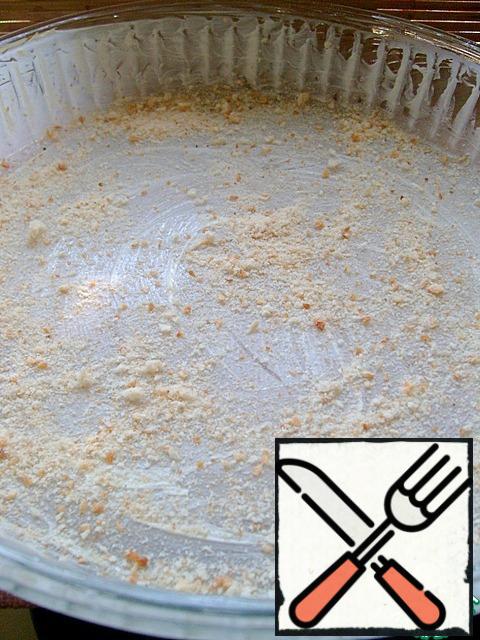 Grease the form with oil and sprinkle with breadcrumbs. Spread a thick layer of apples.
