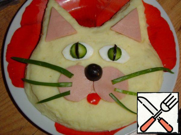Cut out the tongue from the red sweet pepper. So, we got a wonderful cat.
Do you think it would be useful for your child to eat mashed potatoes?