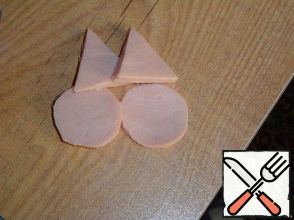 From a thin slice of sausage, cut out two circles-cheeks and two triangles-ears.
