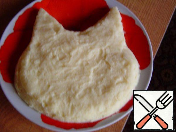 Put a portion of mashed potatoes on a plate and give it the shape of a cat's head.
