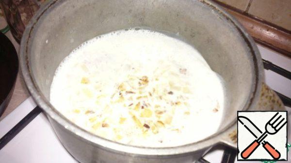 Pour the fried onion into boiling milk and then turn it off.
Stir the milk with the onion and grate half of the necessary cheese. And mix well.