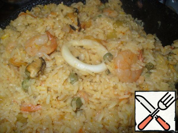 Then stir, add salt to taste, pour lemon juice and about 30 seconds to increase the heat to the lower rice dried or, as was said in the original recipe, "lightly fried".
That's all, wonderful, hearty and very tasty dish is ready! Seafood remain soft, "rubber", despite the relatively long cooking time. Bon appetit!