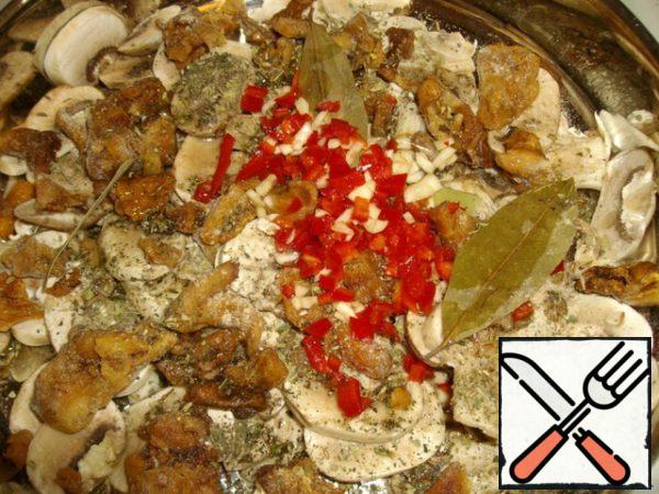 Mushrooms are cut into plates quite large, but you can not cut them. Put the mushrooms in a mold, mix with butter.
Add all the seasonings, bay leaf, finely chopped garlic and chili pepper.