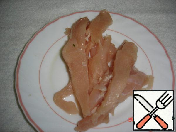 Raw chicken breast cut into strips.