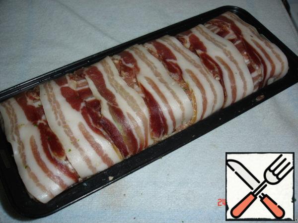 Fill in the form of the rest of the stuffing and wrap strips of bacon.
