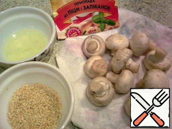 Wash the mushrooms, dry them on a paper towel. Lightly fry the sesame seeds in a dry frying pan until golden brown. Whisk the egg whites.
