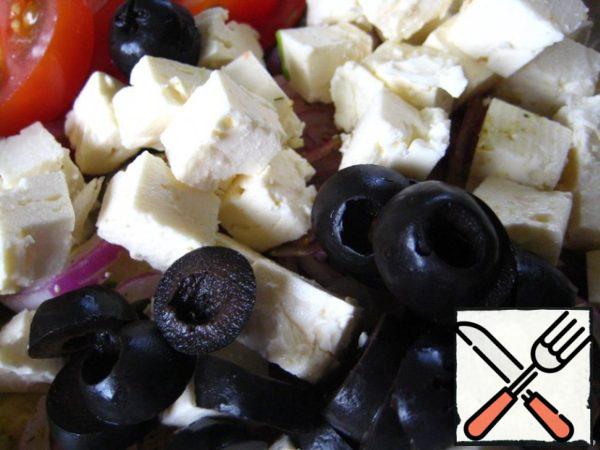 Add olives, cut into 2-3 pieces, and feta cheese - cubes.

