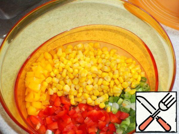 Green onions, paprika finely cut,
corn with finely chopped vegetables put in a salad bowl.