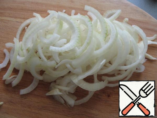 Peel the onion and cut it into half rings.
