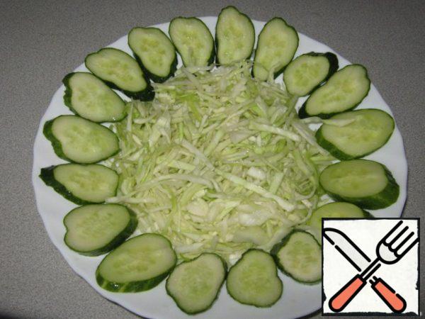 Place the cabbage in the center of the dish and place it around the sliced cucumber.
