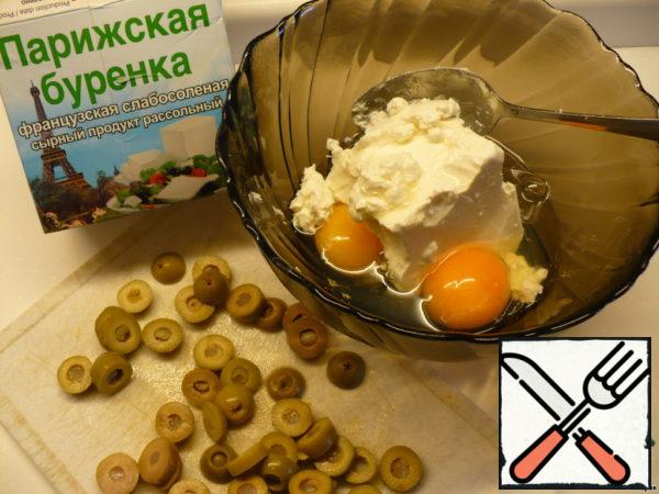 While our peppers were baking and cooling, we are preparing the filling. Mix feta with egg and chopped olives (without them).
