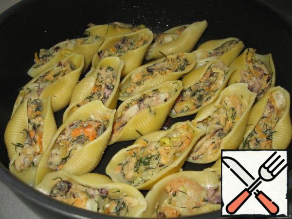 Grease a frying pan with vegetable oil and lay out the stuffed cannelloni.
