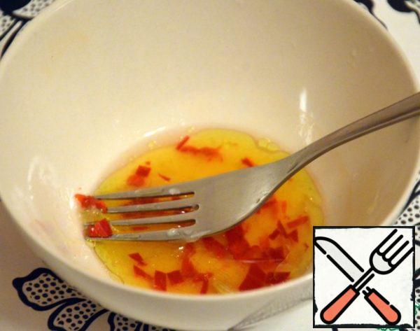 We make the dressing: squeeze the juice from half a lemon, add olive oil and a finely chopped piece of hot pepper, salt a little, mix.
