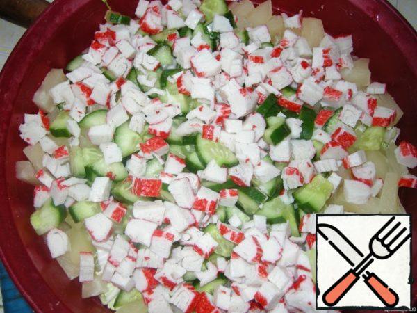 Cut the crab sticks and add to the salad.
