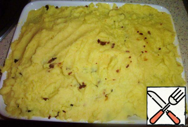 Arrange everything beautifully. First, put half of the mashed potatoes,
then all the whipped and again the remaining mashed potatoes.
Then sprinkle grated cheese on top.
And we send it to a preheated 250 degree oven and bake for 10-15 minutes.