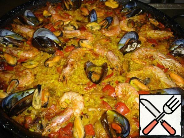 Put the paella dishes in the oven for 10 minutes, then remove from the heat, cover and let stand for another 15 minutes to absorb all the liquid. In this case, the rice will be properly cooked, overcooked rice is a marriage.
Serve the paella immediately. Pour lemon juice over it.