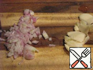 In the meantime, clean and chop onions, garlic cloves razdelyaet knife.