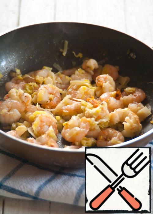 In a heated pan in a small amount of olive oil, fry finely chopped leeks, tiger prawns and cancer necks until Golden brown.