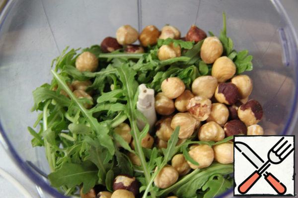 In a blender grind the hazelnuts and arugula.