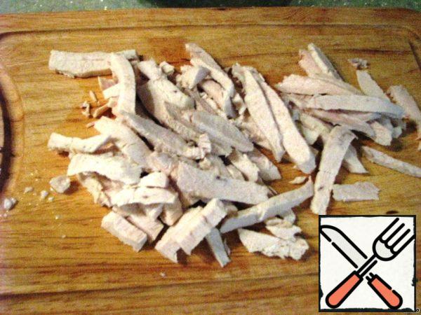 Boil the chicken fillet and cool it right in the broth. Thanks to this, chicken meat will not be dry.
Cut into cubes.
