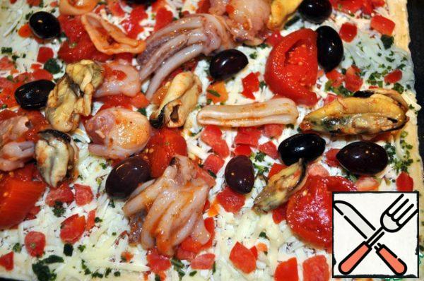 The dough is rolled out in a circle or square, put in layers - sauce, finely chopped red (green) pepper, cheese, olives, seafood, cut tomatoes, cheese and put on top of the rings cut red onions. Put in a hot oven at 200 degrees bake for 20-25 minutes, watching not to overheat.