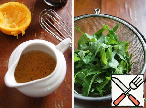 Wash and dry arugula.
Prepare the dressing. Squeeze the orange juice, add oil, salt, pepper, mix with a whisk.
