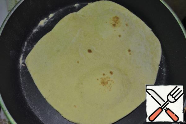 Roll out the dough balls and fry in a frying pan without oil. It is fried very quickly, in just a couple of minutes. Lightly brown on each side and remove. Before the next cake, the form should be wiped from the crumbled flour.
