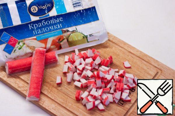 Defrost and chop crab sticks.