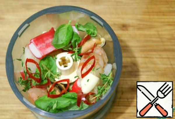 Seafood, crab sticks, garlic, chili rings, basil and thyme leaves are sufficiently coarsely chopped / chopped with a knife / using a blender / chopper.
