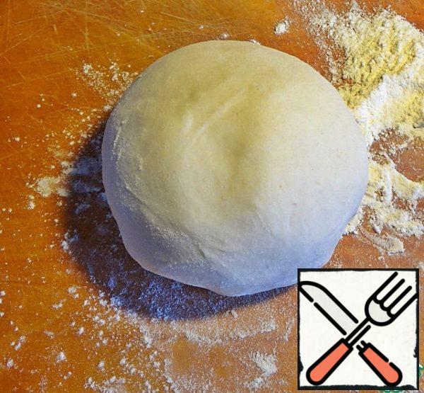 Sift the flour onto the table with a slide, make a recess and pour into it half a cup of hot water, then 1/3 cold and vegetable oil. Knead well to make a smooth, elastic dough. Roll it into a sausage and cut it into cherry-sized pieces.
