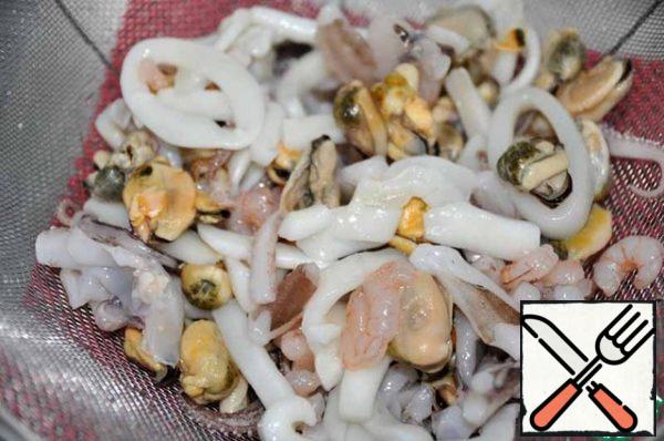 To prepare this snack, you can take any seafood separately, as well as a cocktail. I took a cocktail of squid, mussels, shrimp, octopus.
This scallop snack turns out very well.
Take out the seafood in advance and let them spontaneously thaw, throwing it into a colander.
Then boil about 1 liter of water and discard the seafood in a colander.
