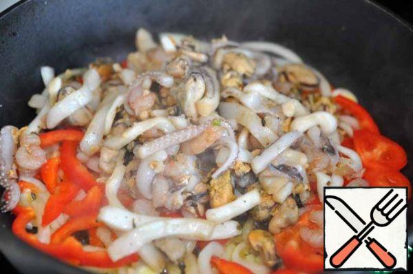 Gently squeeze the seafood out of the marinade and add to the vegetables.
Fry on high heat for 2 minutes, stirring constantly.
