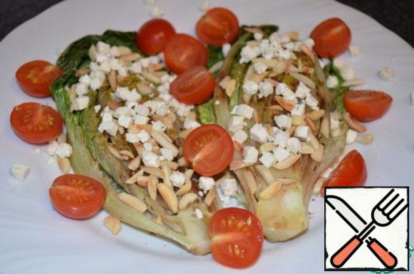 Put the salad on a plate, sprinkle with nuts, finely chopped feta and halves of cherry tomatoes.