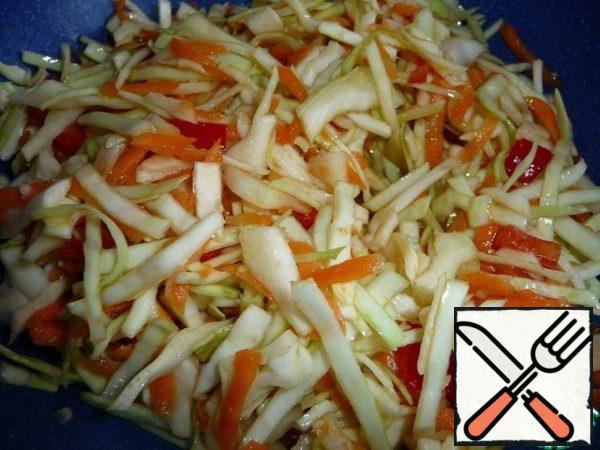 Finely chop the cabbage, grate the carrots on a coarse grater, and cut the pepper into small cubes.
