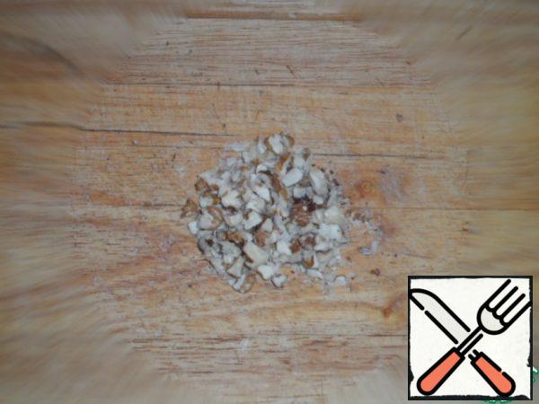 Chop the walnuts. Put the arugula on a plate, put the mushrooms and onions on it, sprinkle with chopped nuts.