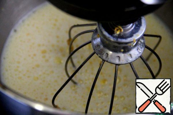 Continuing to beat, slowly pour the hot milk into the eggs.
