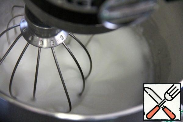 Beat the egg whites well until stable peaks. Add powdered sugar and whisk a little more.
