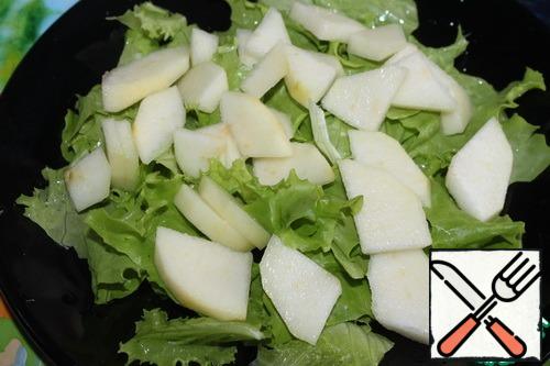 Peel the pear, cut into thin slices, sprinkle with lemon juice. Lay out on lettuce leaves.