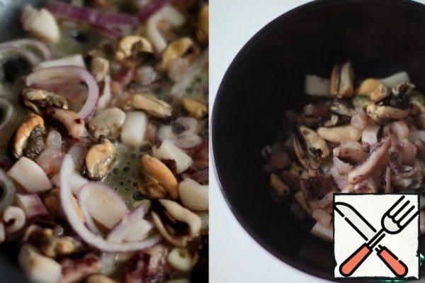 To prepare hot seafood, you need to defrost it. Fry the onion, garlic and seafood in a frying pan.
